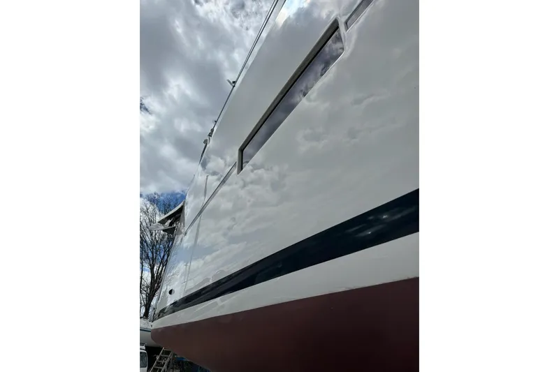  Yacht Photos Pics 2019 Dufour Grand Large 412 Grand Prix yacht hull under cloudy sky.