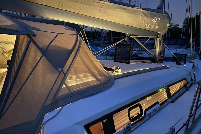  Yacht Photos Pics 2019 Dufour Grand Large 412 sailboat illuminated at dusk, showcasing sleek design.
