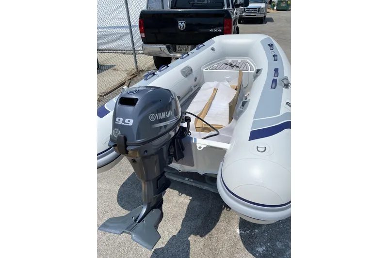  Yacht Photos Pics Inflatable boat with Yamaha 9.9 motor, parked near a black truck.