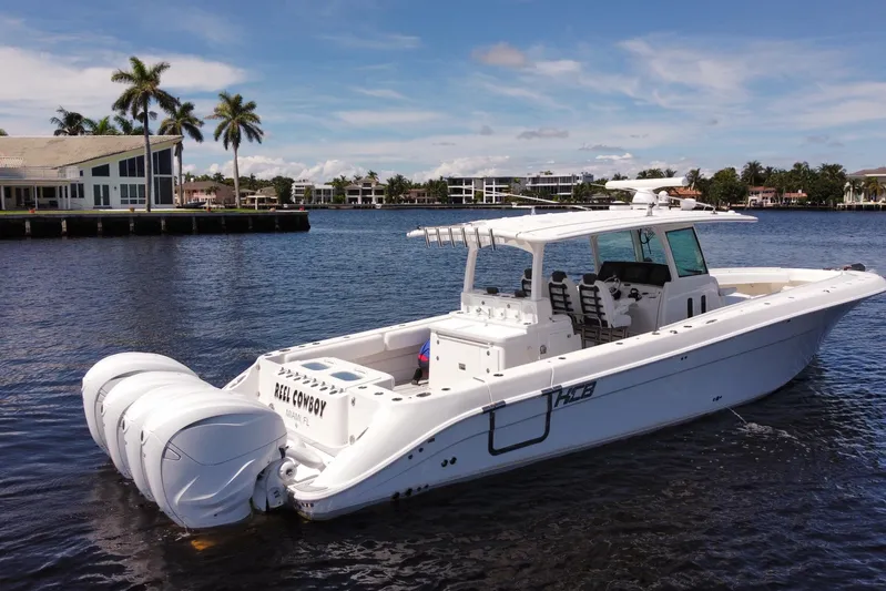  Yacht Photos Pics 2020 HCB 42 Siesta boat on water, with triple outboard engines, near waterfront homes.