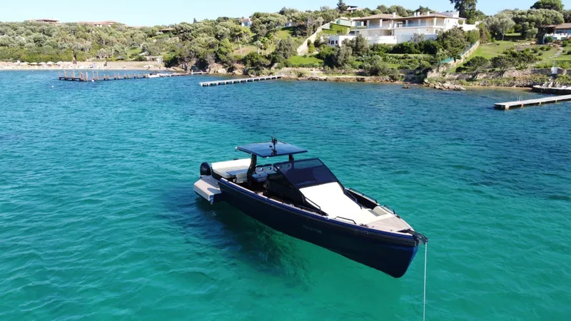  Yacht Photos Pics Seanfinity T4 2021 boat anchored in clear blue water near a scenic coastline.