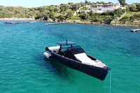 Seanfinity T4 2021 boat anchored in clear blue water near a scenic coastline.