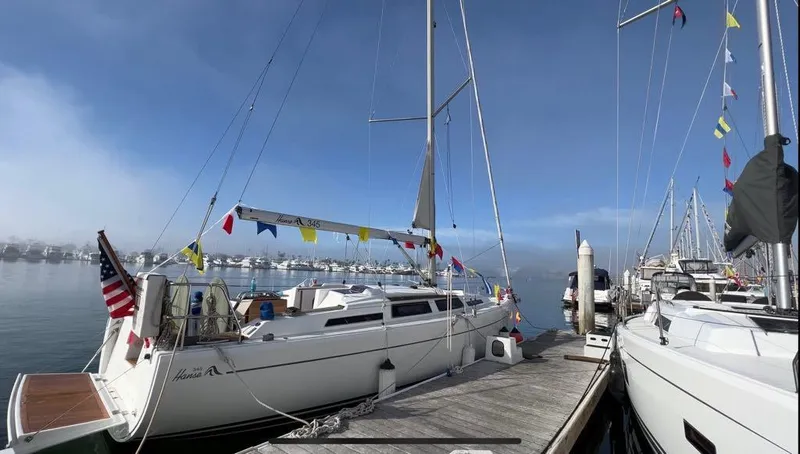 Obatanga Yacht Photos Pics Sailboat Hanse 345, 2014 model, docked with colorful flags and clear blue sky.