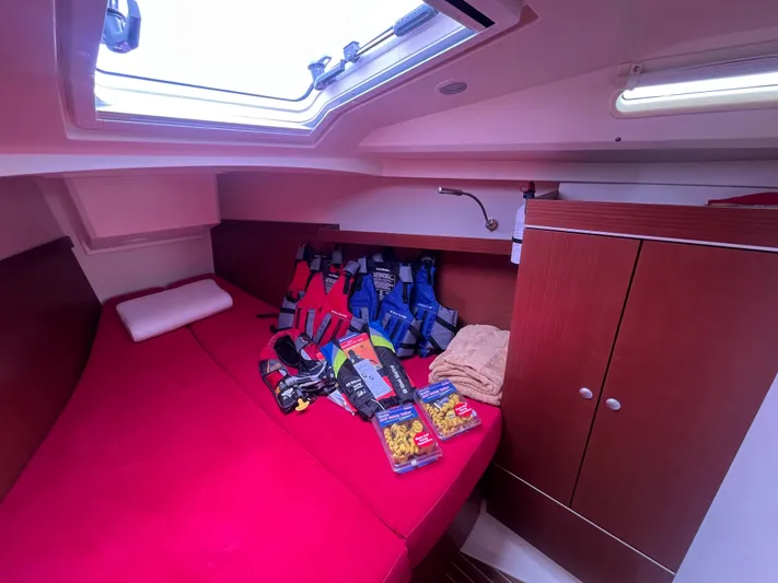Obatanga Yacht Photos Pics Cabin interior of 2014 Hanse 345 yacht with red bedding and life jackets.
