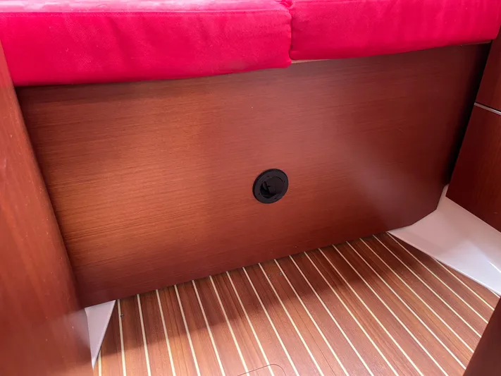 Obatanga Yacht Photos Pics Interior of 2014 Hanse 345 yacht with red cushion and wooden paneling.