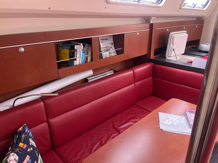 Obatanga Yacht Photos Pics Interior of 2014 Hanse 345 yacht with red seating and wooden cabinetry.
