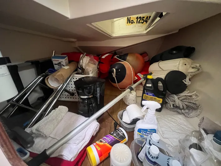 Obatanga Yacht Photos Pics Storage compartment on a 2014 Hanse 345 yacht, filled with cleaning supplies and equipment.