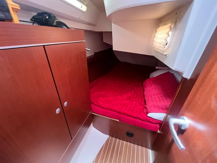 Obatanga Yacht Photos Pics Cozy cabin interior of 2014 Hanse 345 yacht with red bedding and wooden cabinetry.