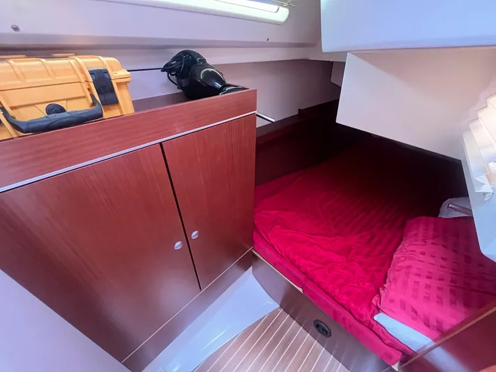 Obatanga Yacht Photos Pics Cozy cabin interior of 2014 Hanse 345 yacht with red bedding and wooden cabinetry.