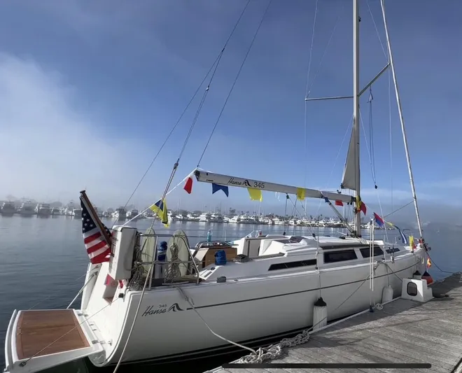 Obatanga Yacht Photos Pics Sailboat Hanse 345, 2014 model, docked with colorful flags and American flag.