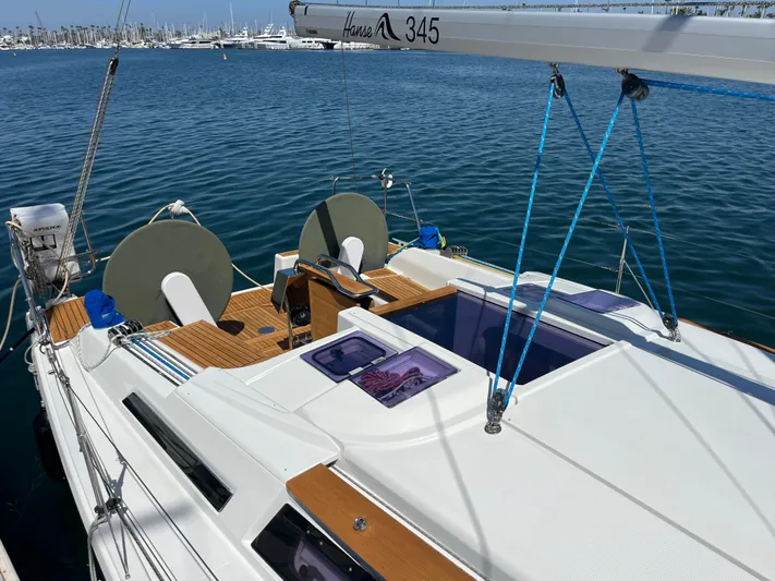 Obatanga Yacht Photos Pics 2014 Hanse 345 sailboat with wooden deck, docked in a marina.