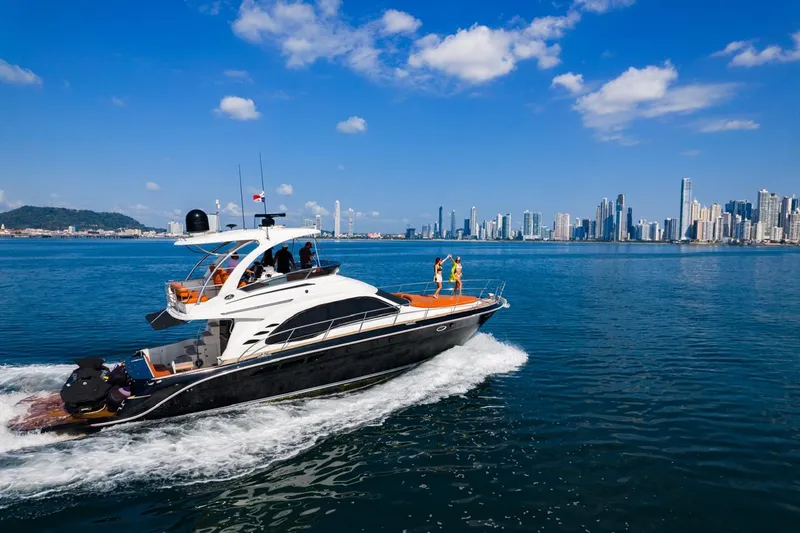  Yacht Photos Pics 2005 Sea Ray Sedan Bridge 520 yacht cruising near a city skyline on a sunny day.