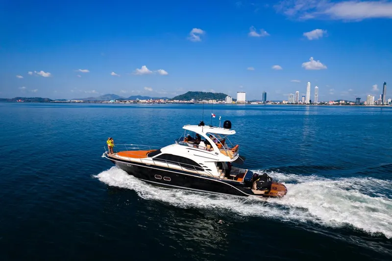  Yacht Photos Pics 2005 Sea Ray Sedan Bridge 520 cruising on a sunny day with city skyline in background.