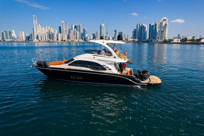  Yacht Photos Pics 2005 Sea Ray Sedan Bridge 520 yacht on water with city skyline backdrop.