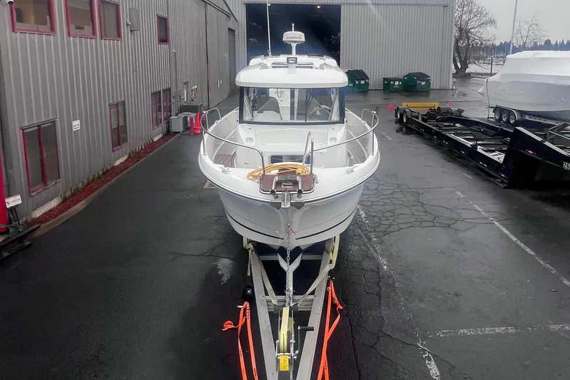  Yacht Photos Pics 2015 Jeanneau Merry Fisher 855 Marlin on trailer outside industrial building.