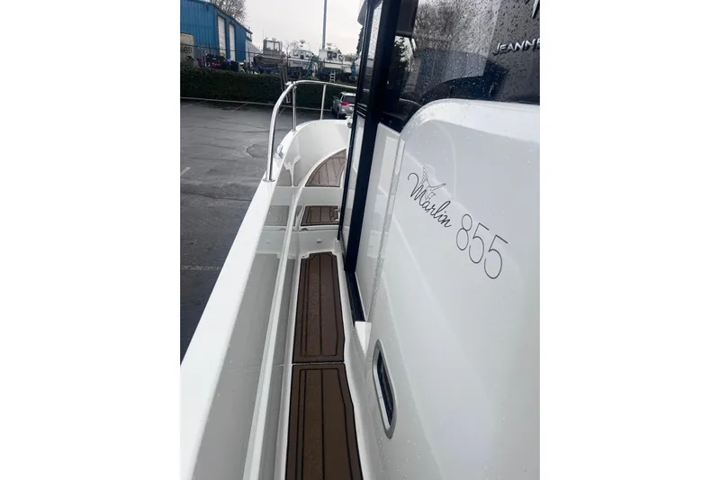  Yacht Photos Pics 2015 Jeanneau Merry Fisher 855 Marlin boat, side view with sleek design and wood accents.