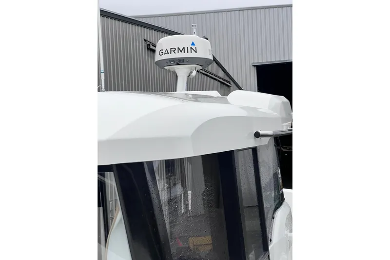  Yacht Photos Pics 2015 Jeanneau Merry Fisher 855 Marlin with Garmin radar, docked near a metal building.