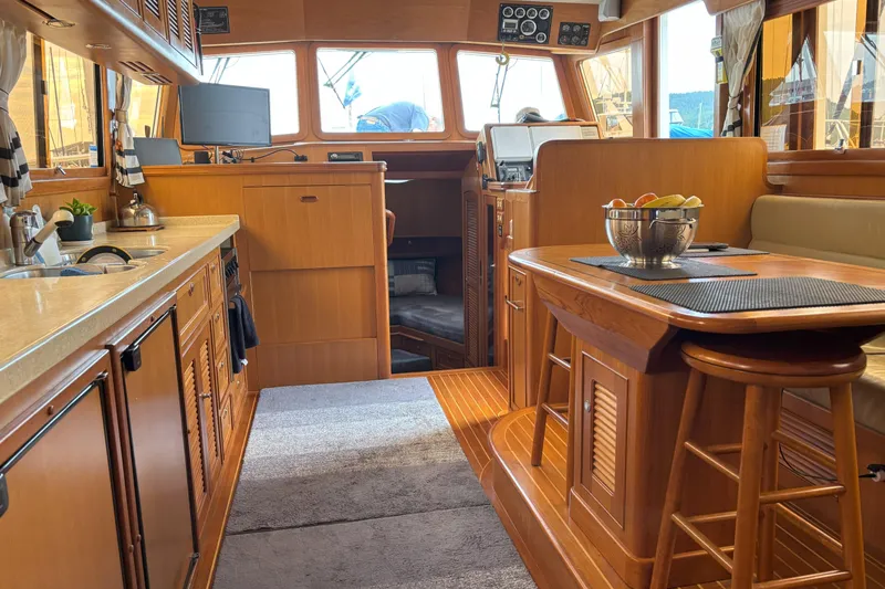 Slainte Yacht Photos Pics Luxurious interior of 2006 Selene 40 Archer yacht with wooden cabinetry and dining area.