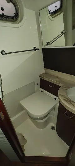  Yacht Photos Pics 2020 Pursuit S 368 Sport boat bathroom with toilet, sink, and mirror.