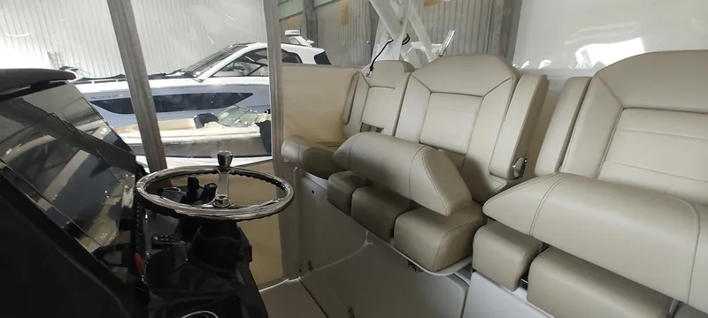  Yacht Photos Pics 2020 Pursuit S 368 Sport boat interior with beige seating and steering wheel in a showroom.