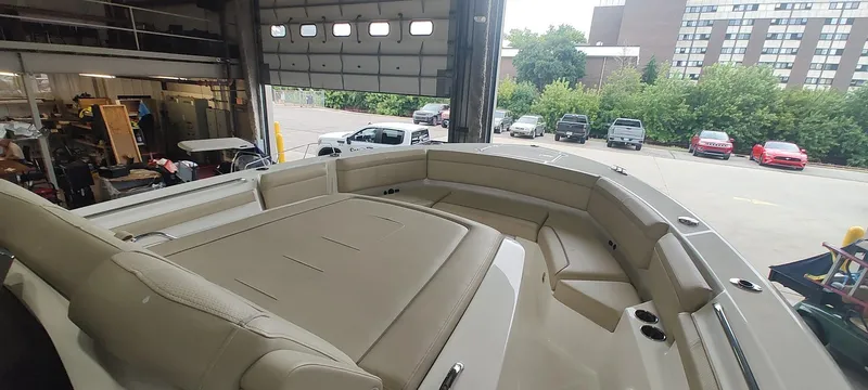  Yacht Photos Pics 2020 Pursuit S 368 Sport boat interior with beige seating in a garage setting.