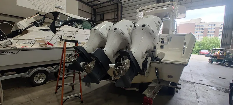  Yacht Photos Pics 2020 Pursuit S 368 Sport boat with triple outboard engines in a garage setting.