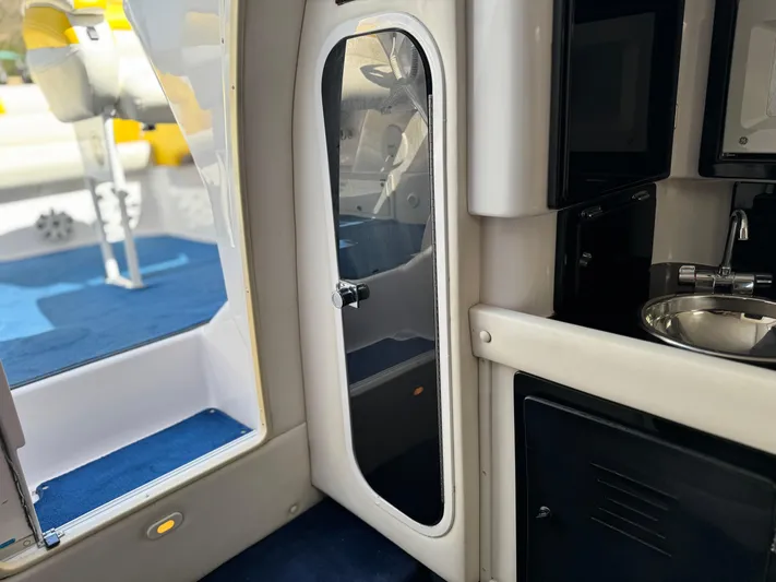  Yacht Photos Pics Interior view of a 2004 Donzi 38 ZX boat, featuring a sleek cabin door and compact kitchenette.