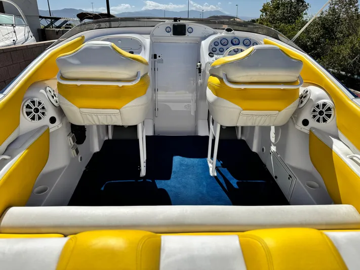  Yacht Photos Pics 2004 Donzi 38 ZX boat interior with yellow and white seating, blue carpet, and control panel.