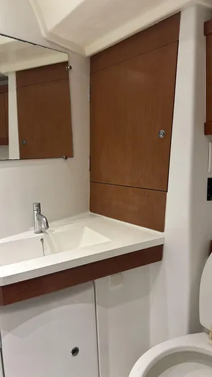 Yacht Photos Pics Beneteau Oceanis 50 bathroom interior, featuring a modern sink and wooden cabinetry, 2013 model.