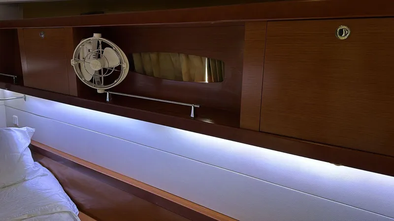  Yacht Photos Pics Interior cabin of 2013 Beneteau Oceanis 50 yacht with wooden cabinets and fan.