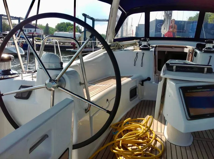  Yacht Photos Pics Cockpit of 2013 Beneteau Oceanis 50 sailboat with steering wheel and navigation equipment.