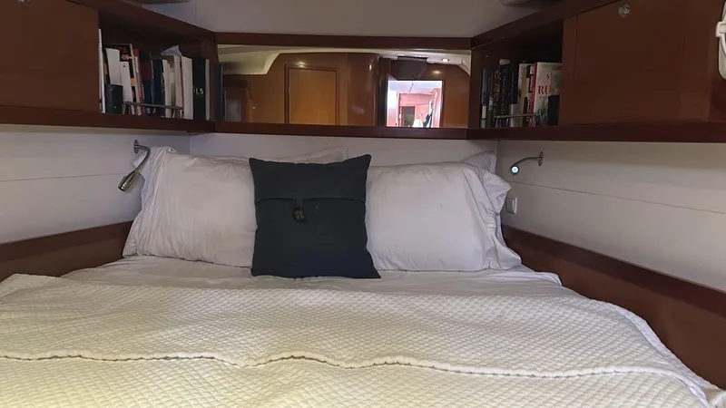  Yacht Photos Pics Cozy cabin interior of 2013 Beneteau Oceanis 50 yacht with bed and bookshelves.