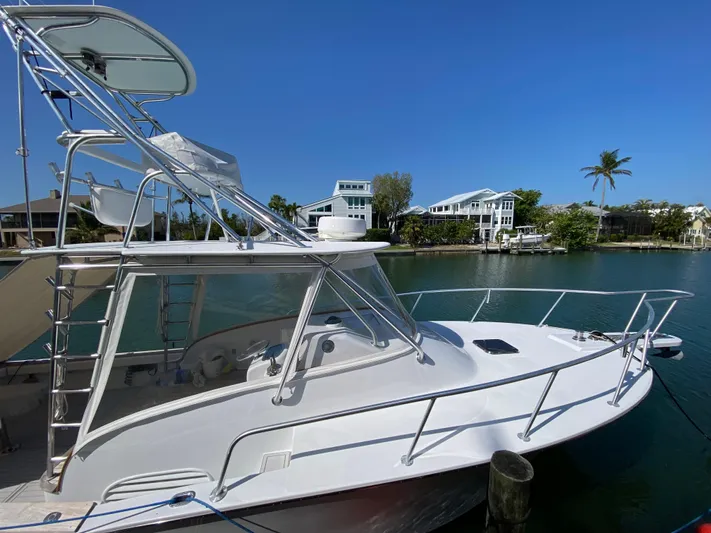  Yacht Photos Pics 1995 L&H 33 boat docked by waterfront homes under clear blue sky.