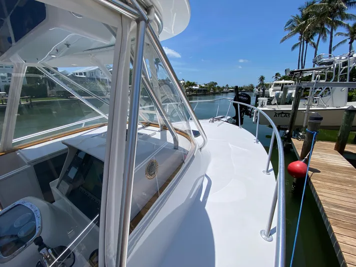  Yacht Photos Pics 1995 L&H 33 boat docked by a scenic waterfront with palm trees.