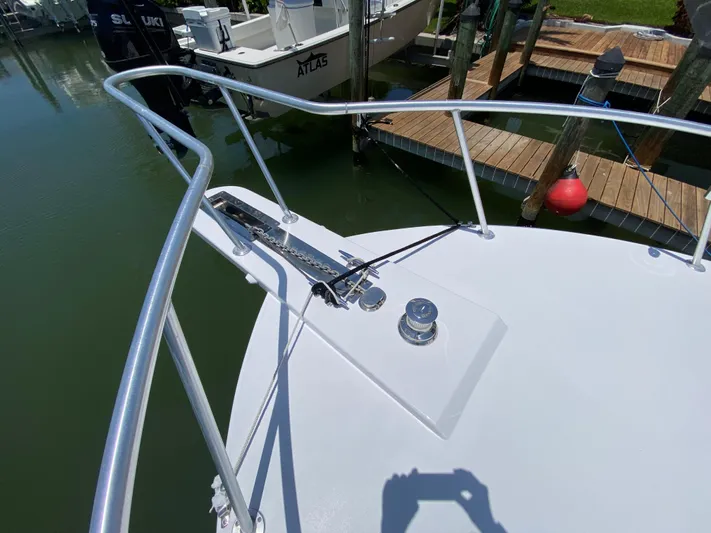  Yacht Photos Pics Bow of 1995 L&H 33 boat with railing and anchor, docked near wooden pier.