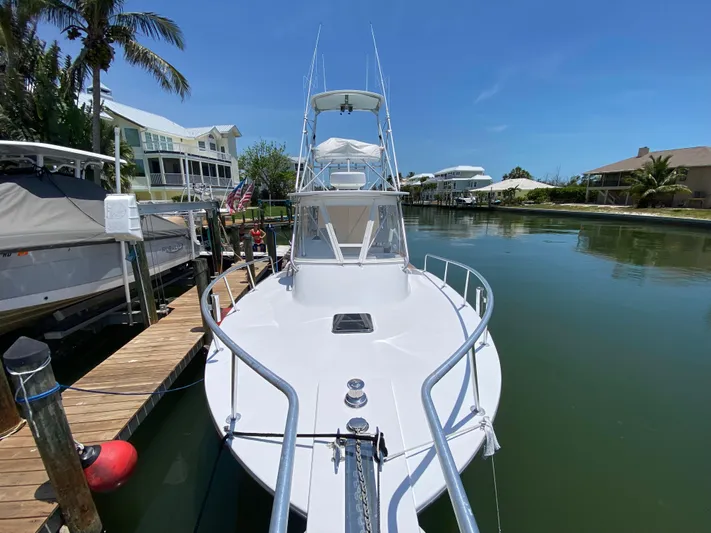  Yacht Photos Pics A 1995 L&H 33 boat docked in a serene canal setting.