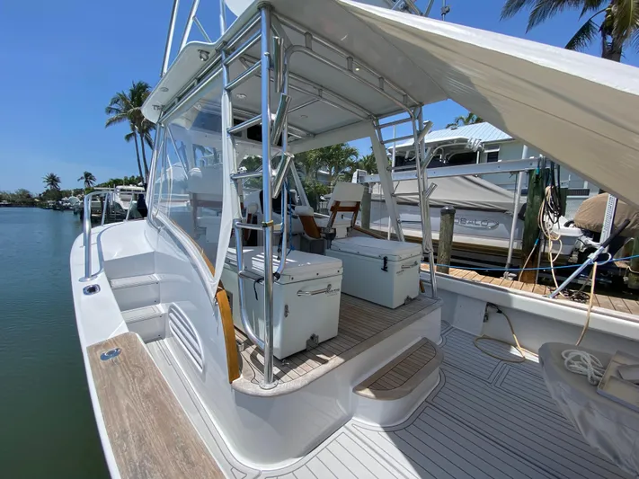  Yacht Photos Pics 1995 L&H 33 boat docked, featuring spacious deck and seating under clear blue sky.