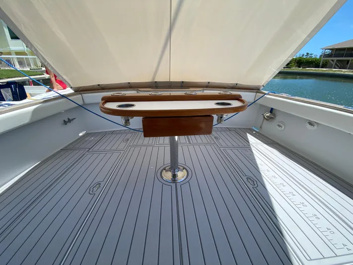  Yacht Photos Pics 1995 L&H 33 boat deck with wooden table, under canopy, near waterfront.