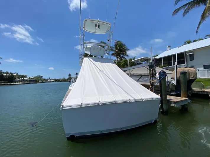  Yacht Photos Pics L&H 33 boat docked by waterfront, covered, under clear blue sky.