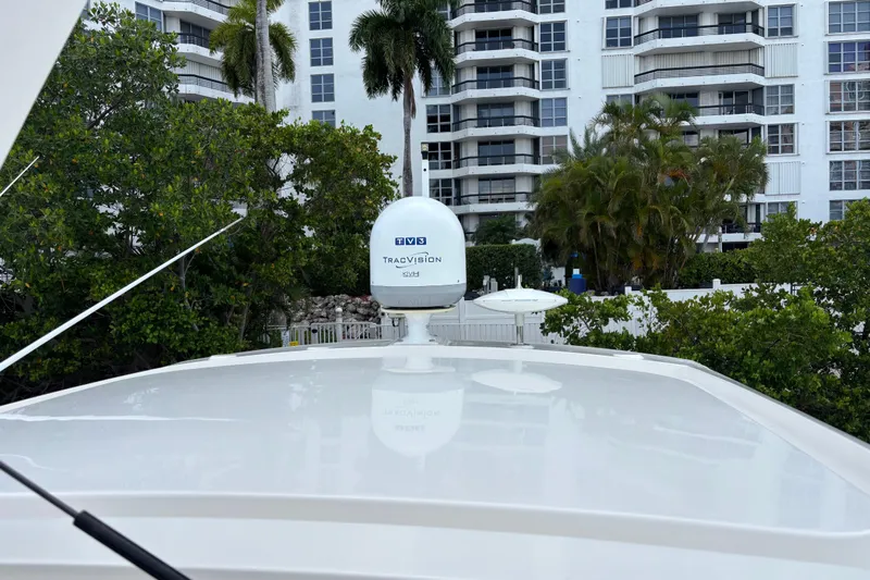  Yacht Photos Pics 2016 Sea Ray 350 Sundancer with TracVision satellite, docked near modern buildings and lush greenery.