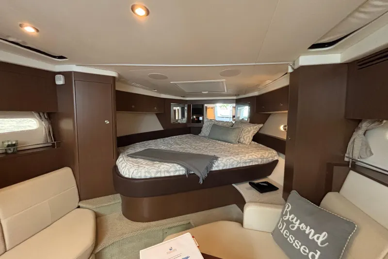  Yacht Photos Pics Luxurious interior of 2016 Sea Ray 350 Sundancer yacht with cozy bed and seating area.