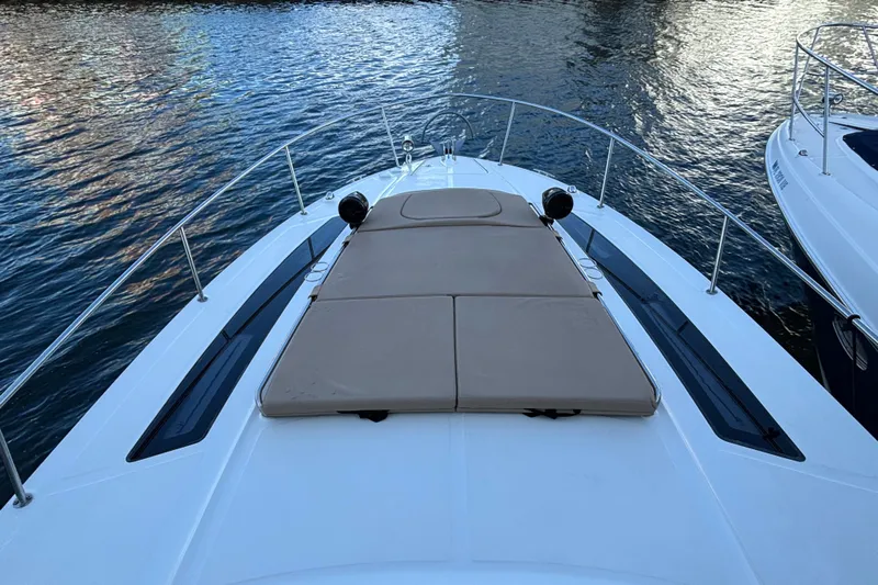  Yacht Photos Pics 2016 Sea Ray 350 Sundancer boat with sunpad on deck, docked on calm water.