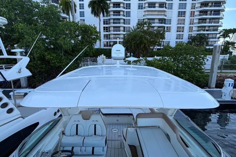  Yacht Photos Pics 2016 Sea Ray 350 Sundancer yacht docked near waterfront buildings and lush greenery.
