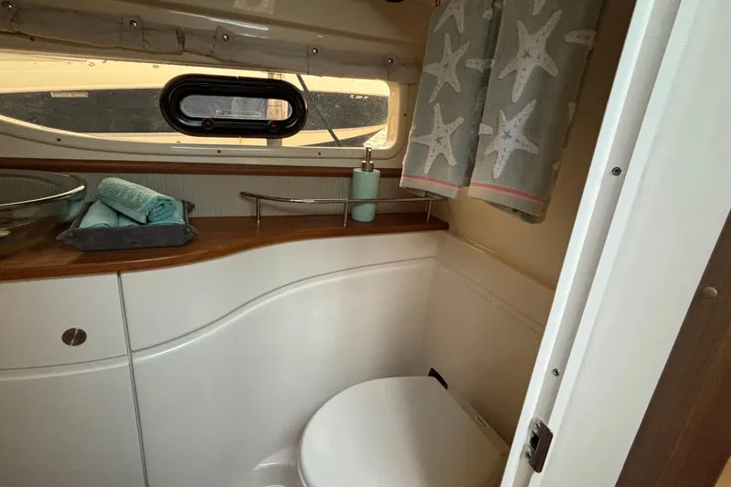  Yacht Photos Pics 2016 Sea Ray 350 Sundancer bathroom with starfish curtains and wooden countertop.