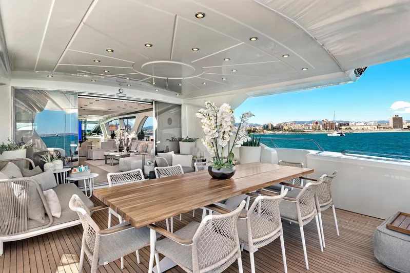  Yacht Photos Pics Luxurious 2004 Mangusta 130 yacht deck with elegant dining area and ocean view.