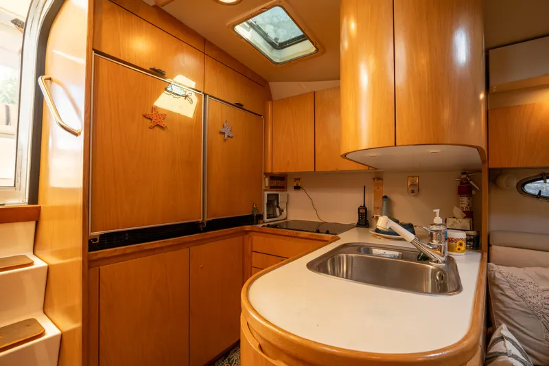  Yacht Photos Pics 1998 Tiara Yachts 4300 Open kitchen with wooden cabinets and stainless steel sink.
