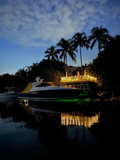  Yacht Photos Pics 1998 Tiara Yachts 4300 Open docked at night, illuminated by nearby lights and palm trees.