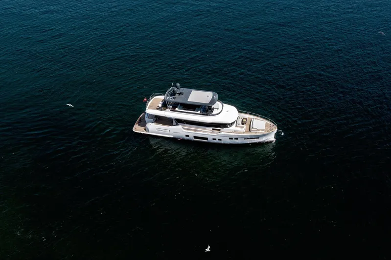  Yacht Photos Pics Aerial view of 2022 Sirena 68 yacht cruising on open water.