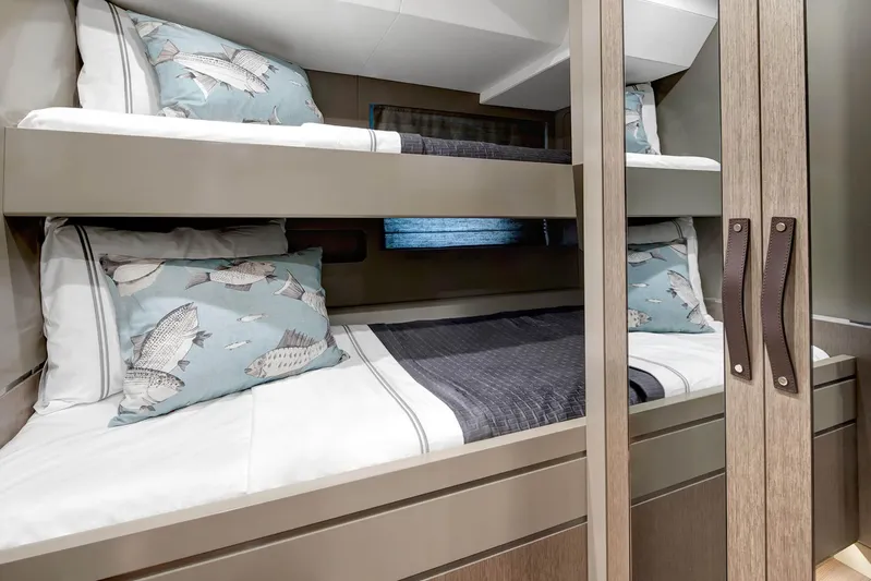  Yacht Photos Pics Bunk beds in a 2022 Sirena 68 yacht cabin with fish-themed pillows.