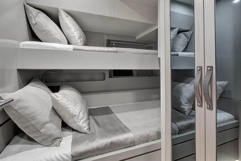  Yacht Photos Pics Bunk beds in a 2022 Sirena 68 yacht cabin with modern design and cozy bedding.